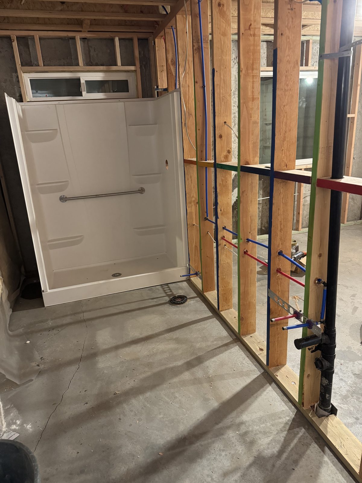 Basement bathroom shower pan and PEX rough-in during a finish in Payson, Utah