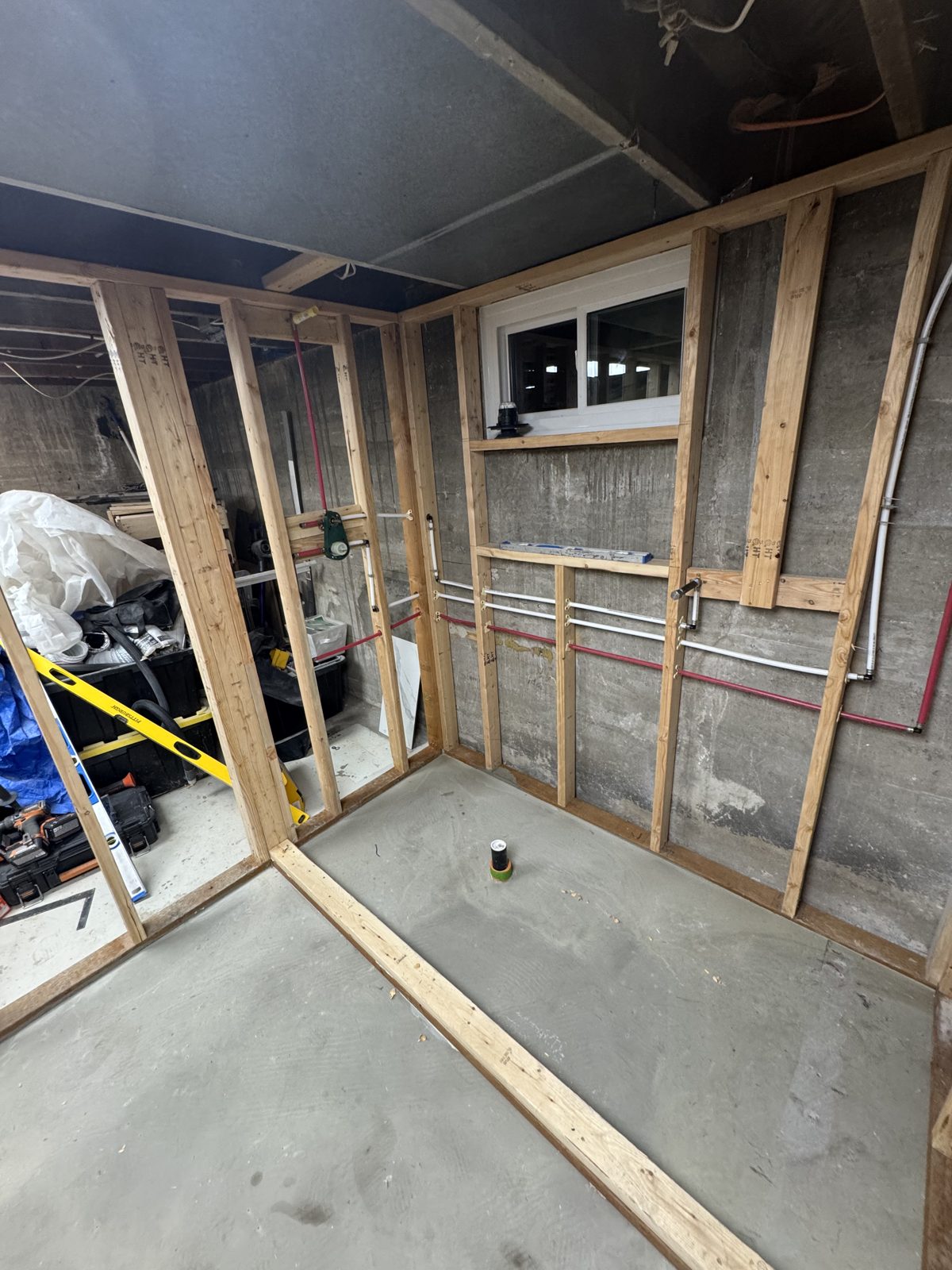 Framed basement bathroom with plumbing rough-in ready for inspection