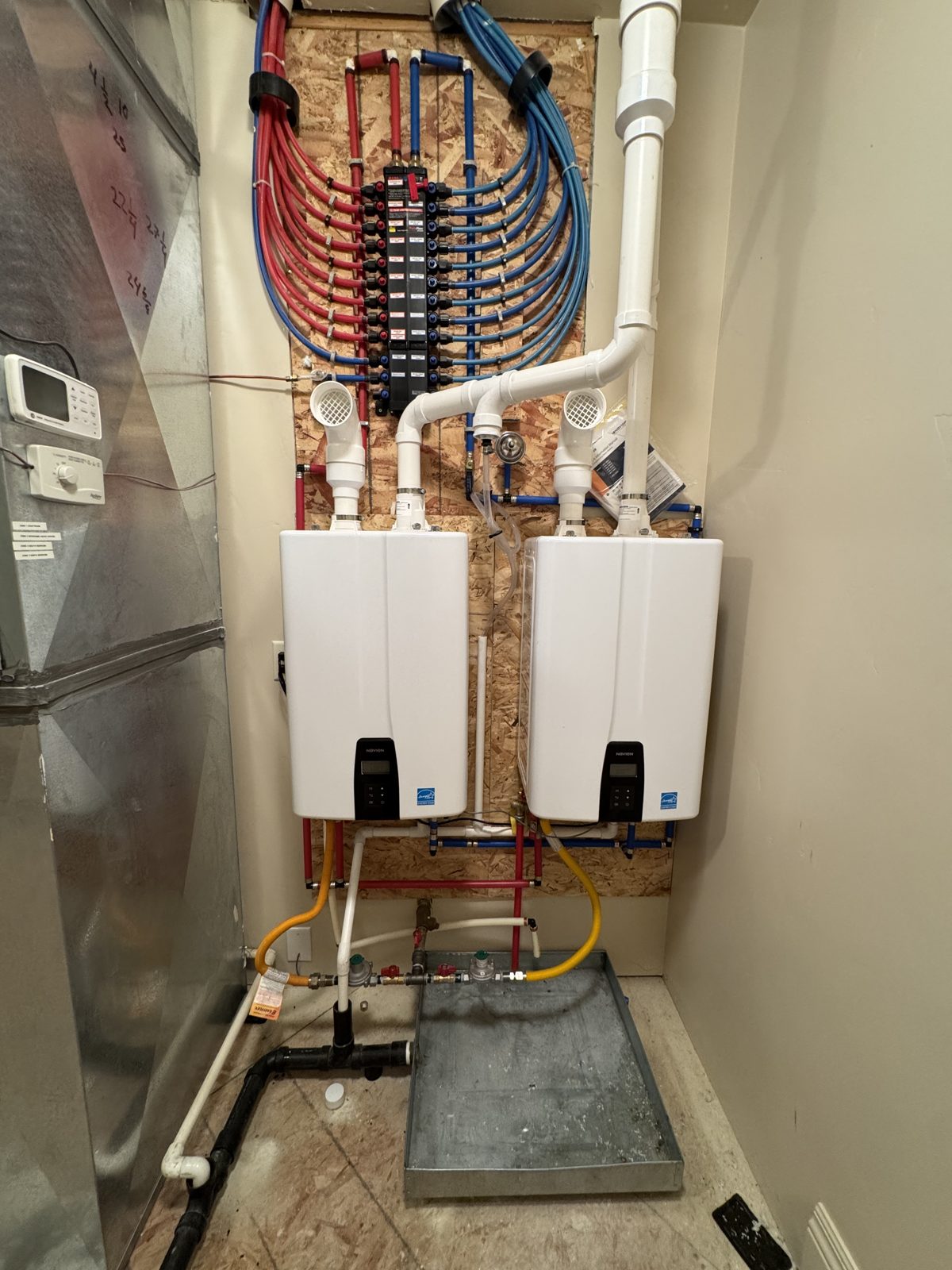 Dual tankless water heaters with PEX manifold installed by Utah Service Pros