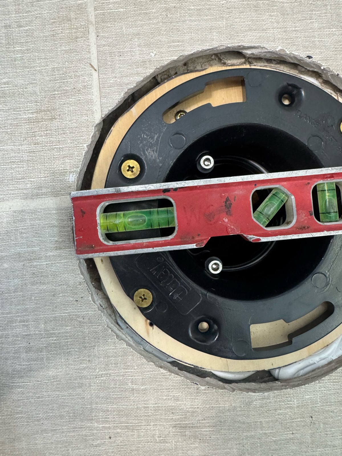 Toilet flange installation checked with a level