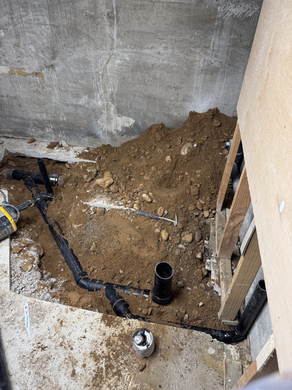 Under-slab drain rough-in excavation for a basement bathroom